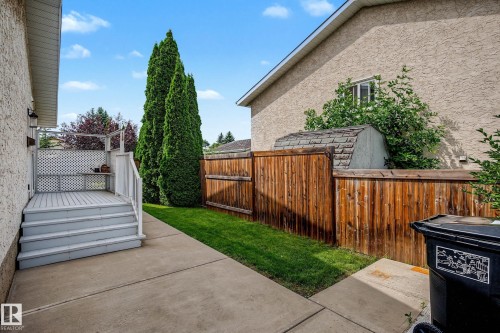 Rear concrete patio with a raised deck featuring white railings and lattice detailing - 10032 173 Avenue Nw, Edmonton, AB - Outdoor