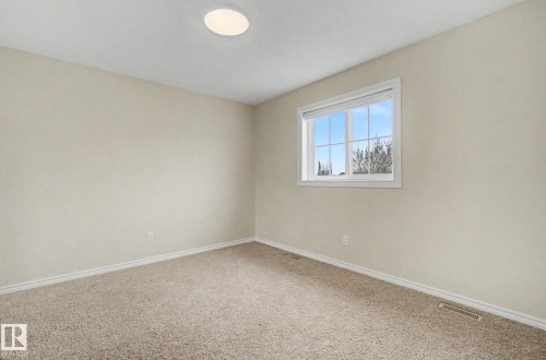 Neutral-toned walls complement the light brown carpeting - 6016 10 Avenue Sw, Edmonton, AB - Indoor Photo Showing Other Room