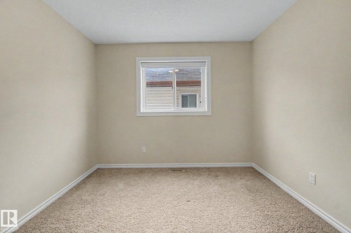 Neutral-toned walls complement the clean white window trim and baseboards - 6016 10 Avenue Sw, Edmonton, AB - Indoor Photo Showing Other Room