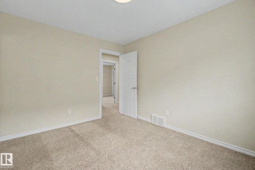 Neutral tone walls complementing light-colored carpet flooring - 6016 10 Avenue Sw, Edmonton, AB - Indoor Photo Showing Other Room