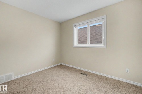 Neutral-toned walls complement plush carpeting and white baseboards - 6016 10 Avenue Sw, Edmonton, AB - Indoor Photo Showing Other Room