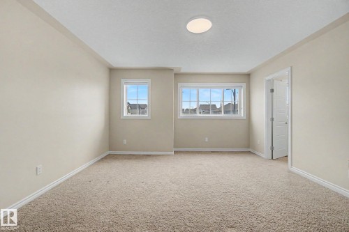 Neutral-toned room featuring light beige walls and complementing carpet flooring - 6016 10 Avenue Sw, Edmonton, AB - Indoor Photo Showing Other Room