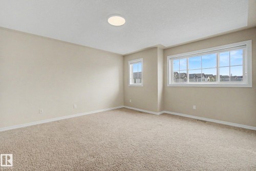 Spacious room featuring neutral carpeting, light-toned wall paint, and white trim - 6016 10 Avenue Sw, Edmonton, AB - Indoor Photo Showing Other Room