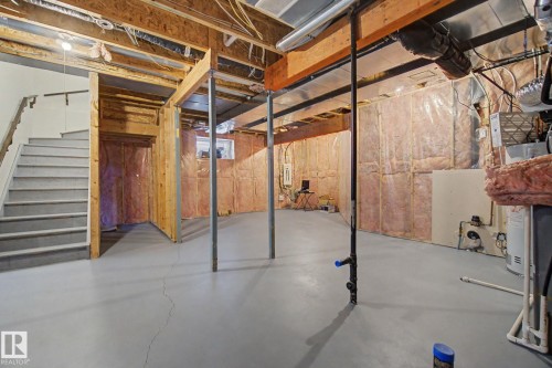 Spacious unfinished basement offering exposed wood joists, structural support beams, stairway access, and insulated walls - 6016 10 Avenue Sw, Edmonton, AB - Indoor Photo Showing Basement