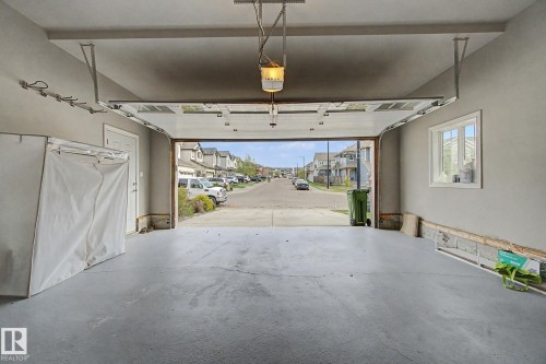 Spacious garage with a concrete floor, overhead lighting, and white trimmed window - 6016 10 Avenue Sw, Edmonton, AB - Indoor Photo Showing Garage