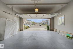 Spacious garage with a concrete floor, overhead lighting, and white trimmed window - 
