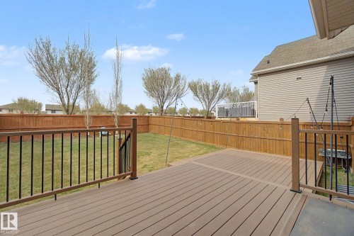 Spacious backyard featuring a composite deck, wrought iron railing, and a wood privacy fence - 6016 10 Avenue Sw, Edmonton, AB - Outdoor With Deck Patio Veranda