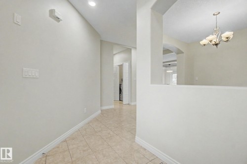 Tiled flooring extending through a neutral-toned hallway with recessed lighting - 6016 10 Avenue Sw, Edmonton, AB - Indoor Photo Showing Other Room