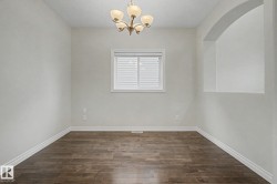 Room featuring wood-finish flooring, white baseboards, and neutral wall tones - 
