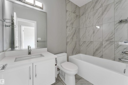 Bathroom featuring a white vanity with an integrated sink and chrome faucet - 6075 180 Avenue Nw, Edmonton, AB - Indoor Photo Showing Bathroom