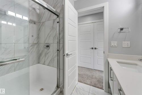 Spacious bathroom featuring a glass-enclosed shower with white marble-finish wall tiling and a white shower pan - 6075 180 Avenue Nw, Edmonton, AB - Indoor Photo Showing Bathroom