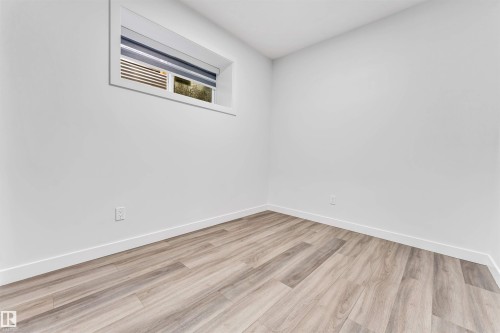 Bright room featuring wood-finish flooring, crisp white walls, and a recessed window - 6075 180 Avenue Nw, Edmonton, AB - Indoor Photo Showing Other Room