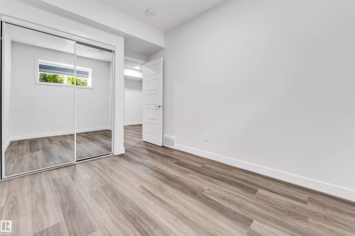 Room featuring wood-finish flooring, white baseboards, and a window with natural light - 6075 180 Avenue Nw, Edmonton, AB - Indoor Photo Showing Other Room