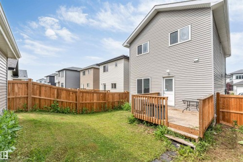 Private backyard featuring a wooden deck with railing, a grass lawn, and a full perimeter wooden fence - 6075 180 Avenue Nw, Edmonton, AB - Outdoor With Exterior