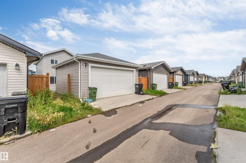 Rear-entry attached garage with a white overhead door and light-toned siding - 6075 180 Avenue Nw, Edmonton, AB - Outdoor