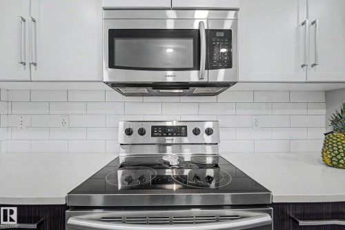Stainless steel range and microwave oven set against white subway tile backsplash - 2314 Wonnacott Crescent Sw, Edmonton, AB - Indoor Photo Showing Kitchen With Upgraded Kitchen