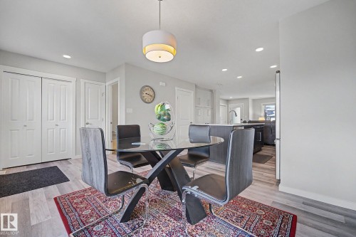 Open-concept dining area featuring light wood-finish flooring and a contemporary pendant light fixture - 2314 Wonnacott Crescent Sw, Edmonton, AB - Indoor Photo Showing Office