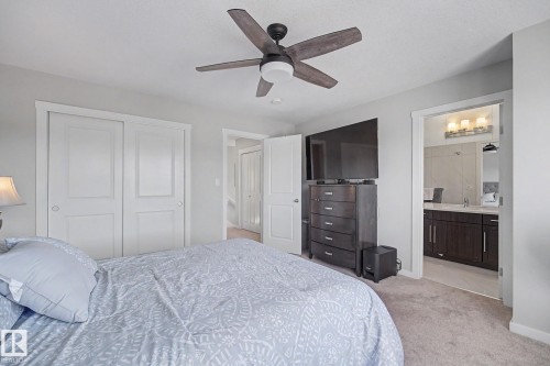 Bedroom featuring light gray wall paint, a ceiling fan with wood-finish blades, and carpet flooring - 2314 Wonnacott Crescent Sw, Edmonton, AB - Indoor Photo Showing Bedroom