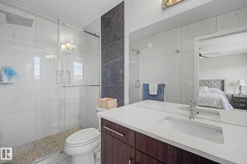 Modern bathroom featuring a wood-grain vanity with a white integrated sink and countertop - 2314 Wonnacott Crescent Sw, Edmonton, AB - Indoor Photo Showing Bathroom