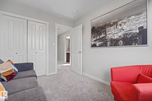 Spacious bedroom featuring neutral carpeting, white six-panel closet doors, and soft recessed lighting - 2314 Wonnacott Crescent Sw, Edmonton, AB - Indoor