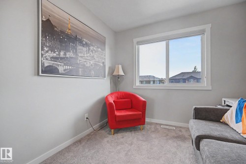 Room featuring light gray walls, gray carpet, white baseboards, and a white-framed window - 2314 Wonnacott Crescent Sw, Edmonton, AB - Indoor