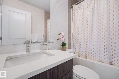 Modern bathroom featuring a floating vanity with an integrated rectangular sink, white quartz countertop, and polished chrome faucet - 2314 Wonnacott Crescent Sw, Edmonton, AB - Indoor Photo Showing Bathroom
