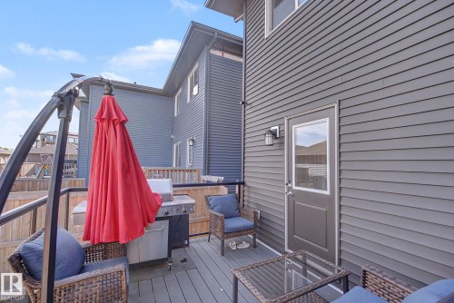 Rear deck featuring composite decking, wood fencing, and gray horizontal siding - 2314 Wonnacott Crescent Sw, Edmonton, AB - Outdoor With Deck Patio Veranda With Exterior
