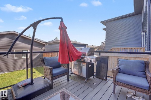 Spacious outdoor deck featuring composite decking, black metal railings with glass inserts, and a wooden privacy fence - 2314 Wonnacott Crescent Sw, Edmonton, AB - Outdoor With Deck Patio Veranda With Exterior