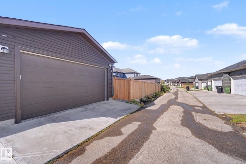 Detached garage featuring panel garage door, horizontal siding, and concrete driveway - 2314 Wonnacott Crescent Sw, Edmonton, AB - Outdoor