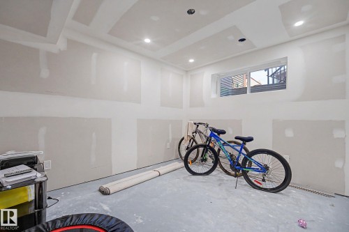 Unfinished room featuring drywall-ready walls, a drop ceiling with recessed lighting, an egress window, and a concrete floor - 2314 Wonnacott Crescent Sw, Edmonton, AB - Indoor Photo Showing Other Room