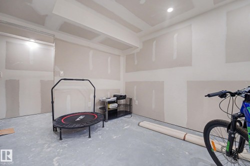 Unfinished interior room with concrete flooring, recessed lighting, drywall walls, and a dropped ceiling with exposed framing - 2314 Wonnacott Crescent Sw, Edmonton, AB - Indoor