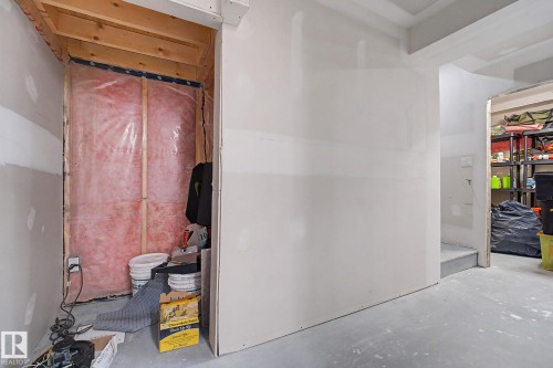Unfinished utility space with exposed wood framing, pink insulation, and a vapor barrier - 2314 Wonnacott Crescent Sw, Edmonton, AB - Indoor
