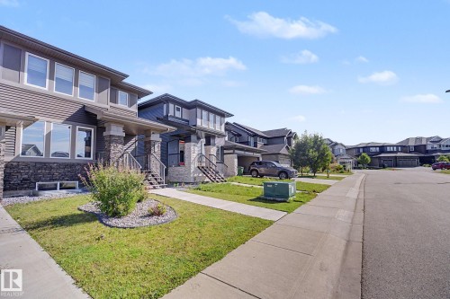 Modern townhome exterior featuring stone accents, horizontal siding, and a covered entry - 2314 Wonnacott Crescent Sw, Edmonton, AB - Outdoor With Facade