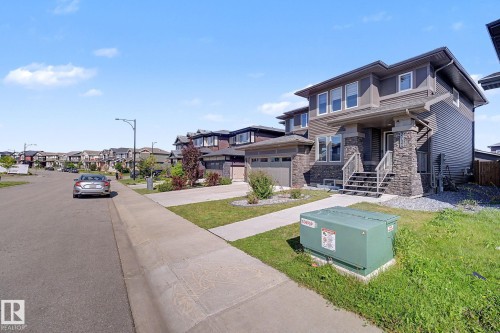 Two-story residence featuring a stone and siding exterior, a covered front entry, and an attached two-car garage - 2314 Wonnacott Crescent Sw, Edmonton, AB - Outdoor