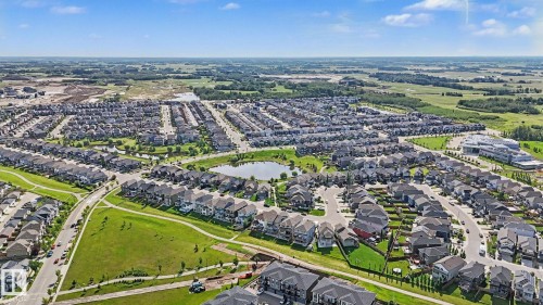 Aerial perspective highlighting a comprehensive residential development with extensive green spaces and multiple retention ponds - 2314 Wonnacott Crescent Sw, Edmonton, AB - Outdoor With View