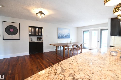 Clearly, the kitchen was purpose built for entertaining, and there is obviously room for an oversized dining table.  Great access to the rear yard and patio from the garden doors.  The wet bar area has lit, glass door cabinetry as well - 572 Lessard Drive Nw, Edmonton, AB - Indoor Photo Showing Dining Room
