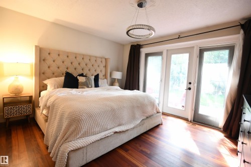 The master suite easily supports king sized furniture and has great private access to the rear yard and patio.  A large walk in closet, and fully features ensuite, with a glass walled shower round out this great space - 572 Lessard Drive Nw, Edmonton, AB - Indoor Photo Showing Bedroom