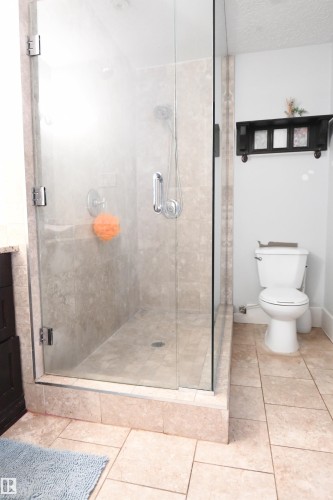 The master suite easily supports king sized furniture and has great private access to the rear yard and patio.  A large walk in closet, and fully features ensuite, with a glass walled shower round out this great space - 572 Lessard Drive Nw, Edmonton, AB - Indoor Photo Showing Bathroom