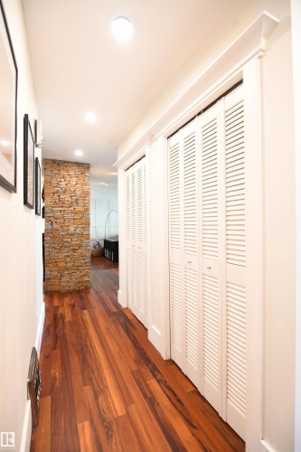 The Brazilian Tigerwood flooring really is a standout feature in the home, and continues from the entertaining spaces, through the hallway and past it's large closets, all the way into the 3 bedrooms - 572 Lessard Drive Nw, Edmonton, AB - Indoor Photo Showing Other Room