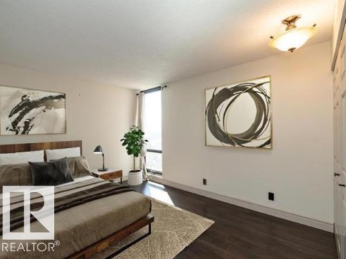 Spacious room featuring dark wood-finish flooring and a large window - #1203 10025 113 St Nw, Edmonton, AB - Indoor Photo Showing Other Room