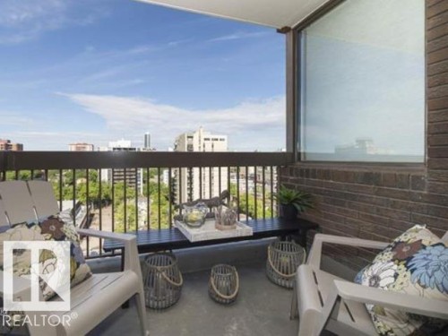 Private balcony featuring a dark brown metal railing, concrete flooring, and an exterior brick wall - #1203 10025 113 St Nw, Edmonton, AB - Outdoor With Exterior