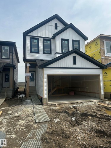 Modern two-story home featuring a clean white and dark charcoal exterior with vertical siding, double-peaked roofline, and architectural detail - 18011 73 Street Nw, Edmonton, AB - Outdoor With Facade