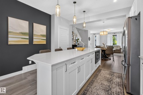 Kitchen island featuring a white countertop, under-counter built-in appliance, and pendant lighting - 6 Daniel Street, Fort Saskatchewan, AB - Indoor Photo Showing Kitchen With Upgraded Kitchen