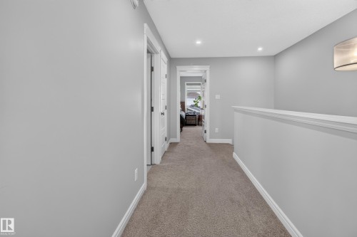 Carpeted hallway with light gray walls, recessed lighting, and white trim - 6 Daniel Street, Fort Saskatchewan, AB - Indoor Photo Showing Other Room