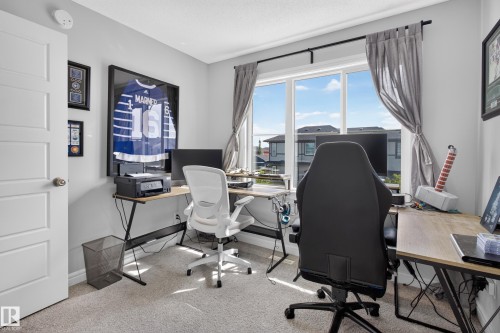 Bright room featuring a large window with exterior views, light-colored carpeting, a white paneled door, and neutral wall tones - 6 Daniel Street, Fort Saskatchewan, AB - Indoor Photo Showing Office