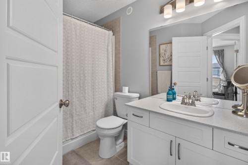 Bathroom featuring a single vanity with an integrated sink, polished chrome faucet, and white cabinetry - 6 Daniel Street, Fort Saskatchewan, AB - Indoor Photo Showing Bathroom