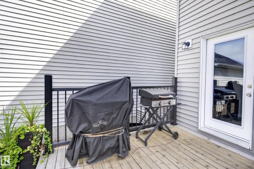 Outdoor deck featuring wood-finish flooring, black metal railing, and white vinyl siding - 6 Daniel Street, Fort Saskatchewan, AB - Outdoor With Deck Patio Veranda With Exterior