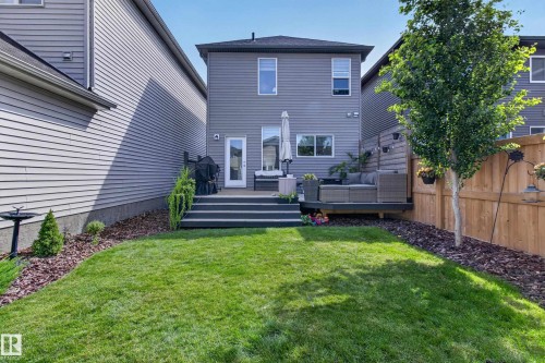 Manicured lawn with a multi-level deck featuring dark composite material - 6 Daniel Street, Fort Saskatchewan, AB - Outdoor With Deck Patio Veranda