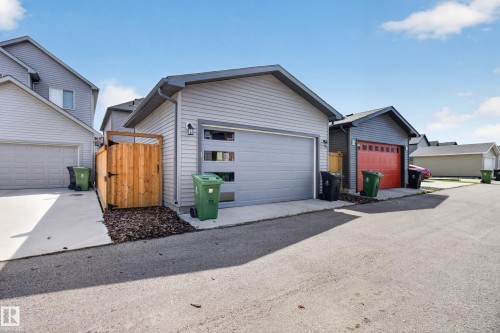 Detached garage featuring light grey horizontal siding, a contemporary garage door with horizontal windows, and a dark shingle roof - 6 Daniel Street, Fort Saskatchewan, AB - Outdoor With Exterior