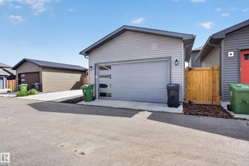 Detached garage with horizontal siding and a modern garage door featuring frosted glass panels - 6 Daniel Street, Fort Saskatchewan, AB - Outdoor With Exterior